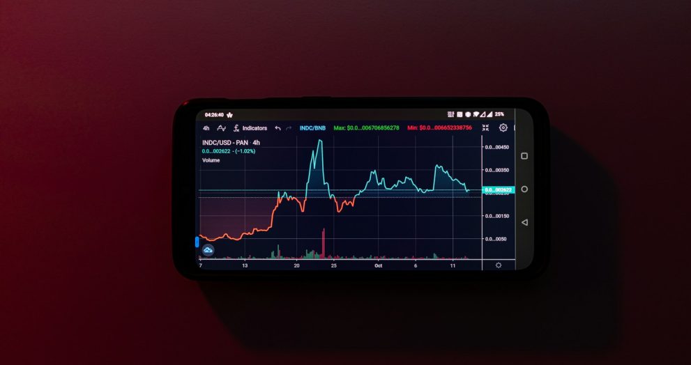 a cell phone displaying a stock chart on a red background