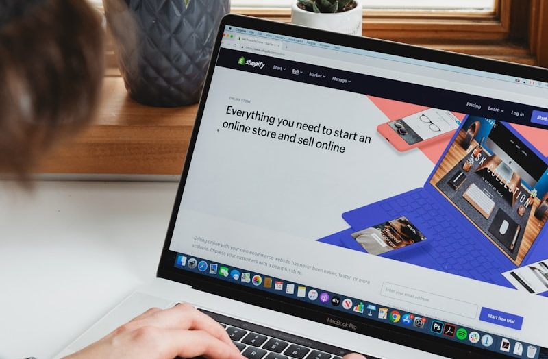 person using macbook pro on white table