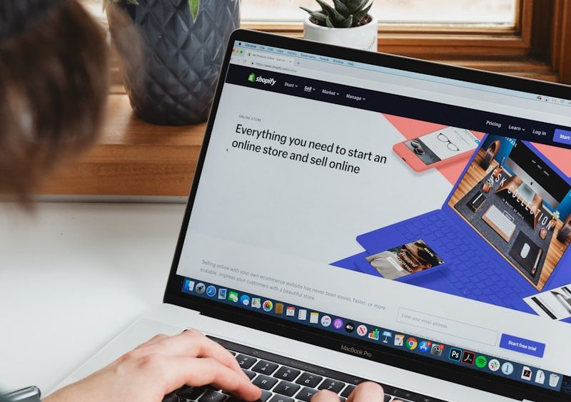 person using macbook pro on white table