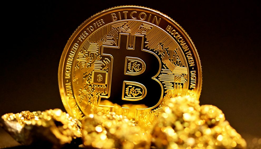 a bitcoin sitting on top of a pile of gold nuggets