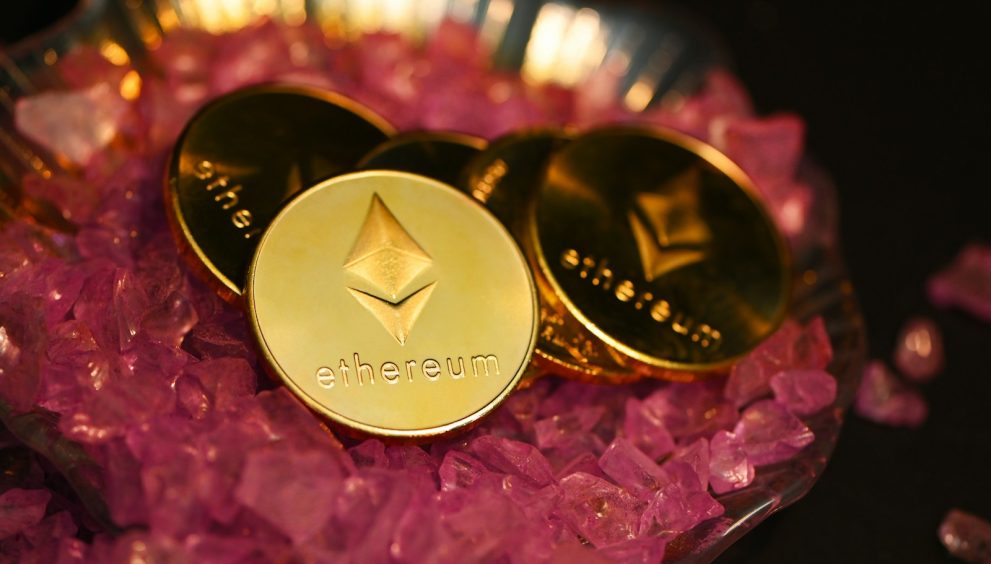 two gold coin sitting on top of a pile of pink crystals