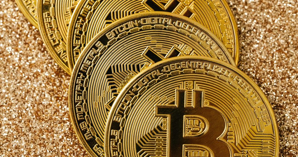 Golden Bitcoin cryptocurrency coins stacked on a glittering surface representing digital wealth and blockchain.